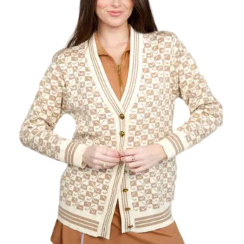 Woman wearing a patterned cardigan over a dress on a gray background
