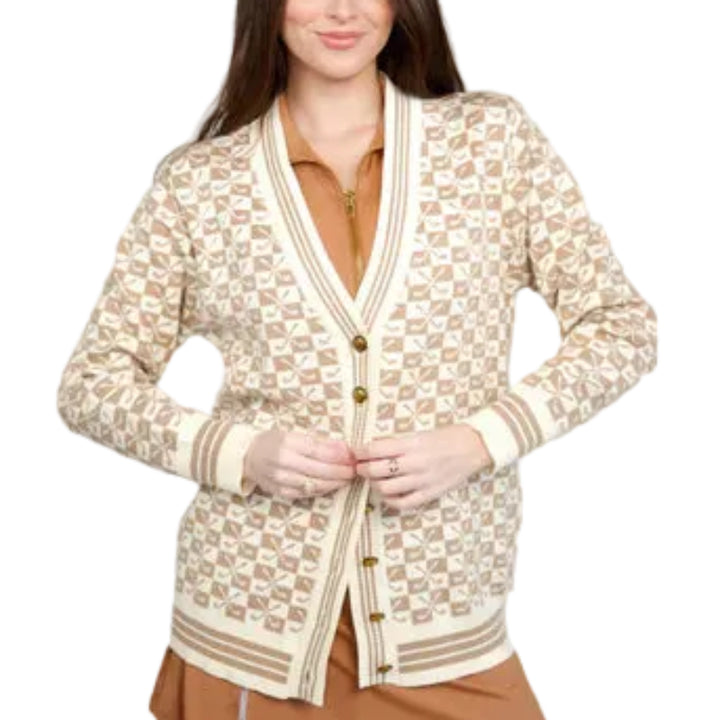 Woman wearing a patterned cardigan over a dress on a gray background